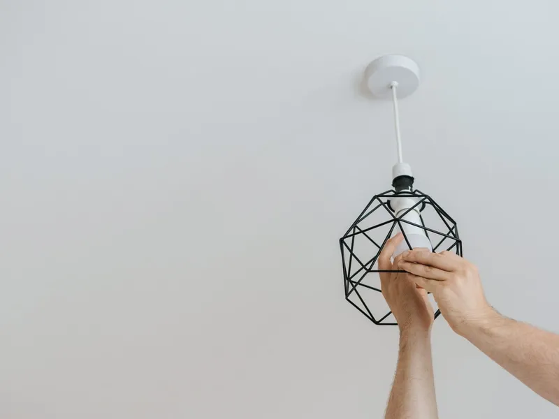 Electrician installing a pendant light fixture in an Owasso, OK home